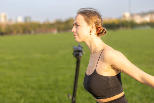 Beautiful young blonde woman is exercising on the outside.