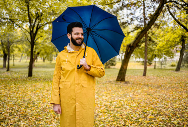 istock Smiling man with a blue umbrella 2185124106
