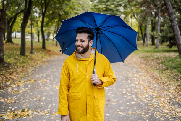 istock Smiling man with a blue umbrella 2185124290