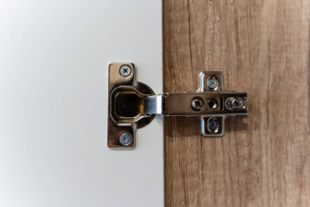 istock This closeup image vividly displays a modern cabinet hinge that is securely attached to a stylish wooden door design 2185126317