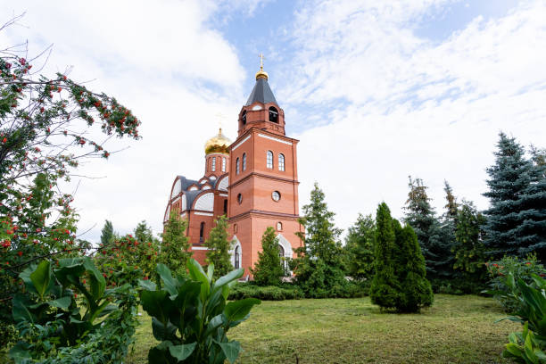 istock A large and impressive red brick church, complete with a bell tower, is beautifully surrounded by lush green trees and wellmaintained grass, creating a picturesque scenery 2185126340