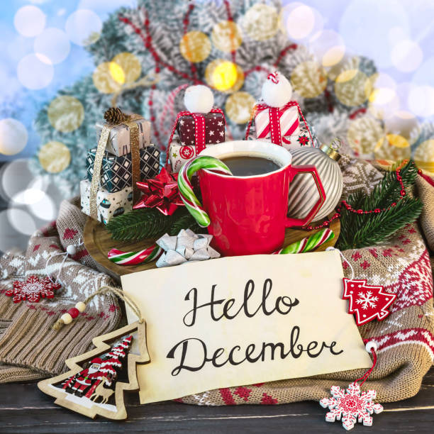 istock Lettering on paper hello December, red cup of coffee, Christmas decorations, gift boxes, lollipops, warm sweater, fir branches 2185127744