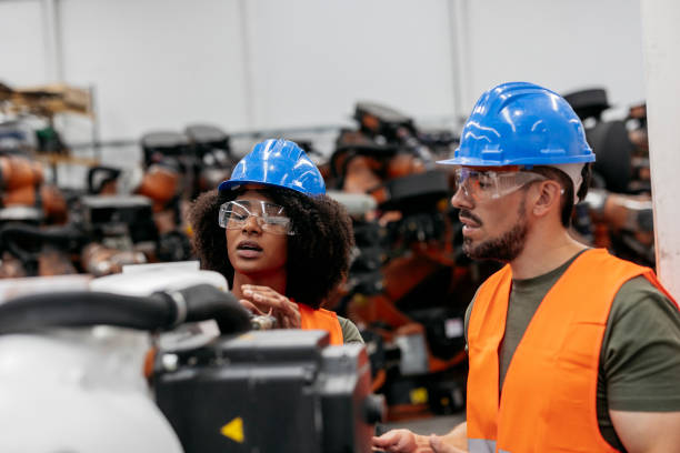 istock Engineers maintaining robotic arms in factory 2185128104
