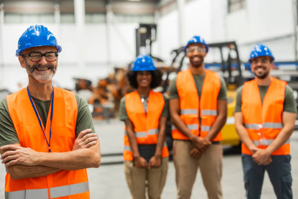 istock Smiling engineers posing with arms crossed in factory setting 2185128152