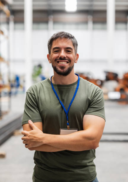 istock Smiling engineer posing with crossed arms in factory 2185128172