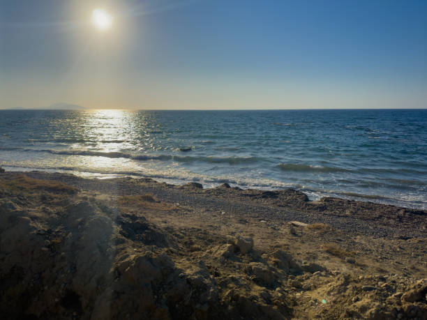 istock Sunset Over a Tranquil Beach With Gentle Waves and a Clear Sky Near the Coastline 2185128652