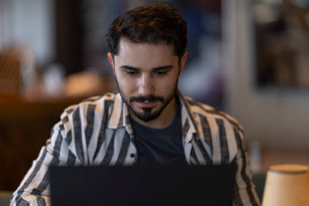 istock Focused young adult man working on laptop in cafe 2185132571