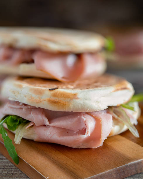istock Stack of crescentine tigelle with mortadella and rocket on wooden board 2185133015