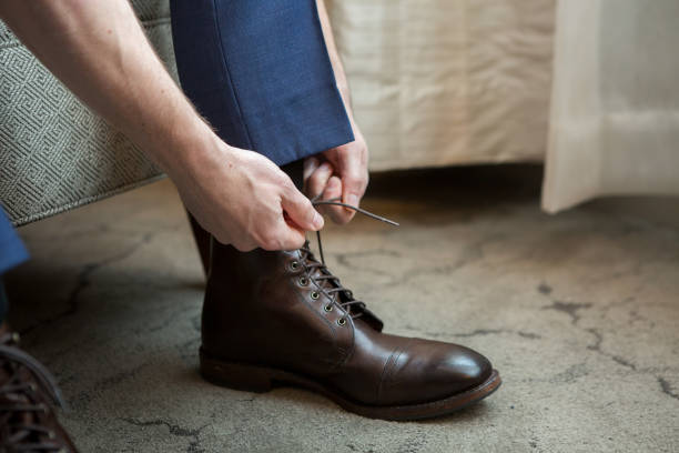 istock Man Tying Boots in Casual Setting, Preparing for the Day 2185135687