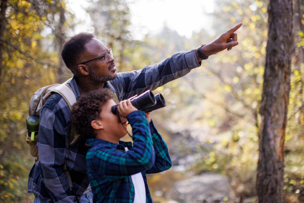 istock Father and son explore nature together with binoculars in the forest 2185137355