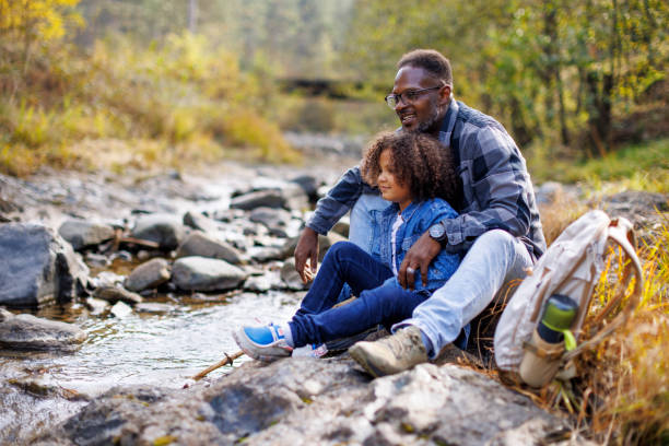 istock Father and child enjoying a peaceful moment by the stream 2185137439