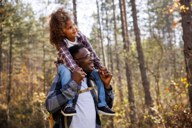 istock Father giving his daughter a piggyback ride during forest hike 2185137523