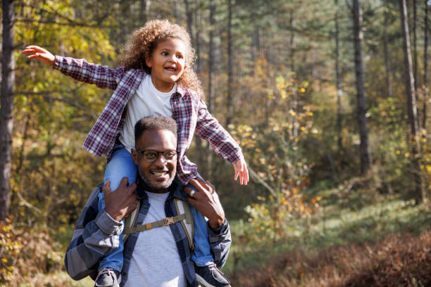 istock Father giving his daughter a piggyback ride during forest hike 2185137526