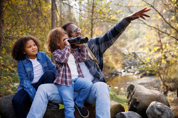 istock Father and daughters enjoying nature and exploring the forest 2185137531