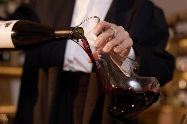 istock Elegant Hand of Unrecognizable Sommelier Holding Glass Pitcher 2185140399