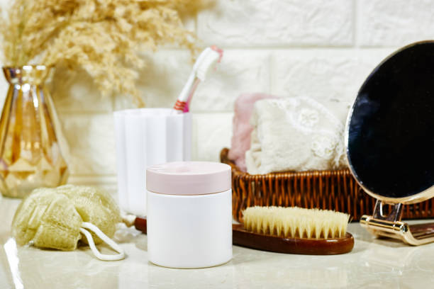 istock A neatly arranged bathroom countertop with various bath essentials, cream jar on marble background 2185143802