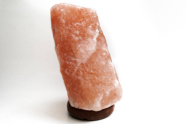 Isolated orange pink himalayan salt lamp over white background