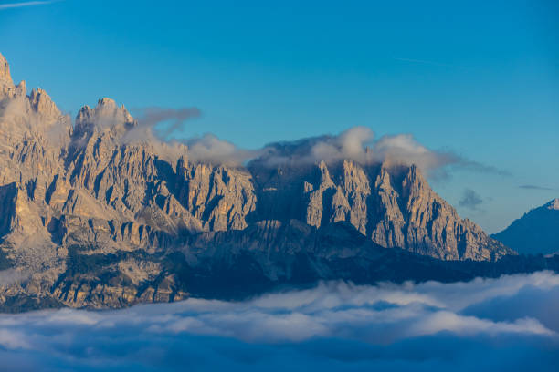 Mountains above the clouds stunning landscape. High rocky peaks rising through mist, this scene captures dramatic high-altitude views with soft cloud cover and rugged terrain in Dolomiti Alps