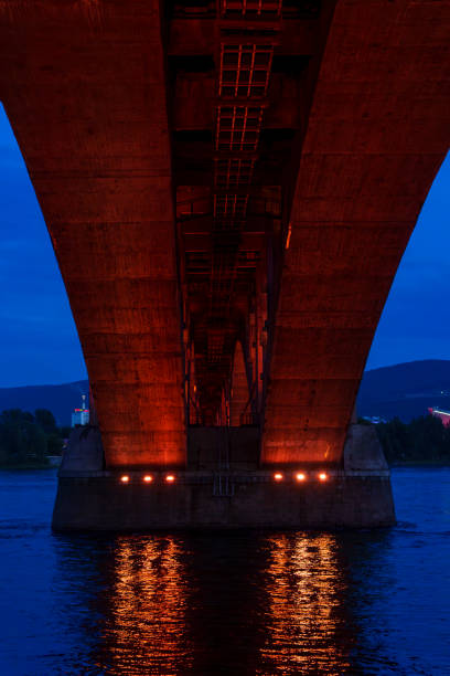 istock Underneath view of illuminated bridge over river at dusk 2185147647