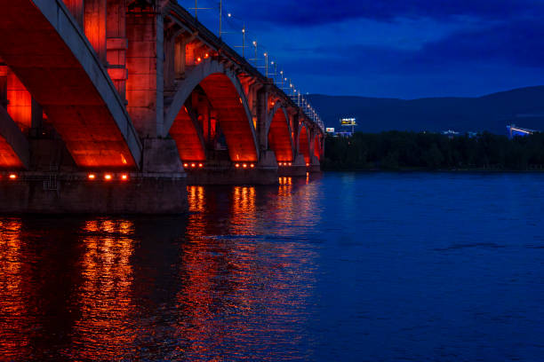 istock Illuminated bridge over river at dusk with reflections on wate 2185147649