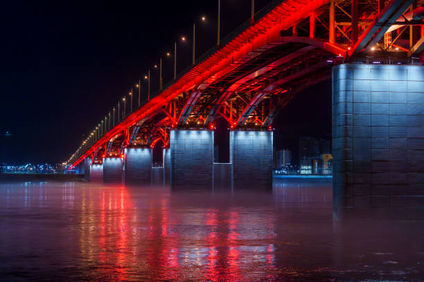 istock Red illuminated bridge over river at night with mist and reflections 2185147685