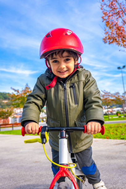 istock A young boy is riding a bike with a red helmet on 2185154662