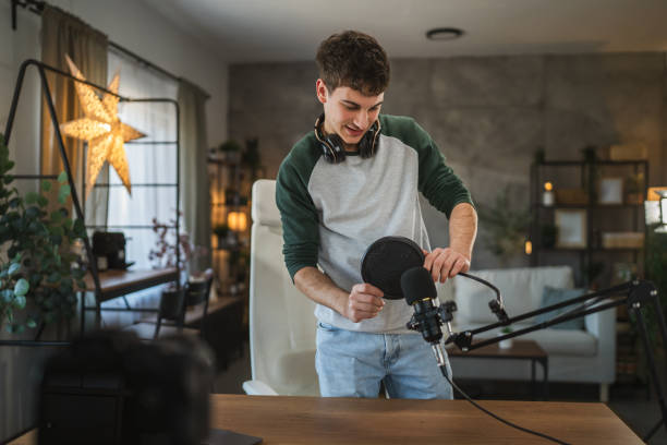 istock man blogger stand and prepare microphone for new video at home studio 2185158240