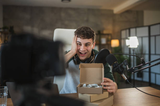 istock Young adult man influence open gifts while recording a live stream 2185158241