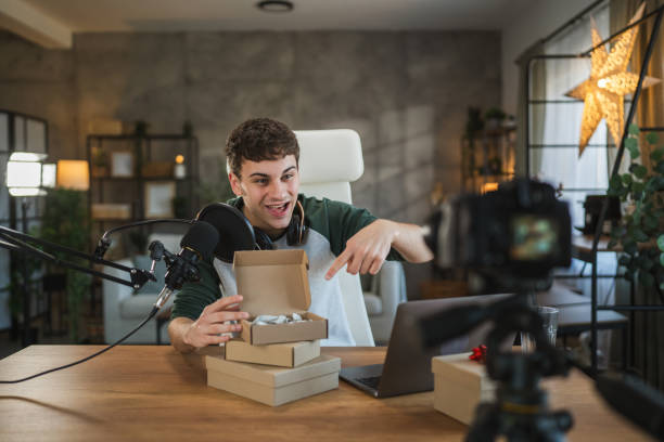 istock Young adult man influence open gifts while recording a live stream 2185158453