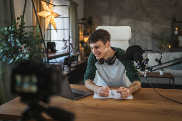 istock Young man blogger or v-logger write notes for new video at home studio 2185158514