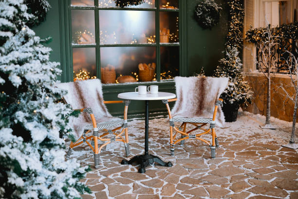 istock Cozy winter scene with chairs and warm drinks in a snowy courtyard setting 2185162941