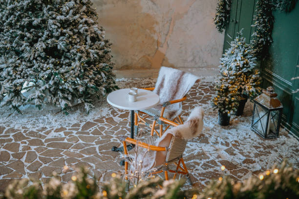 istock Cozy winter seating area with a table and hot drinks surrounded by snow 2185162960