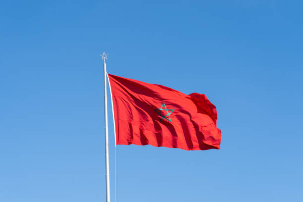istock National flag of Morocco waving with a blue sky background. 2185171794