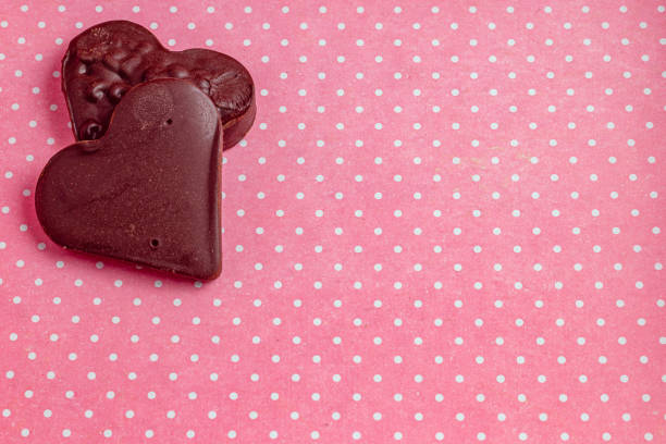 Composition of chocolate hearts on a pink background with light dots High quality photo.