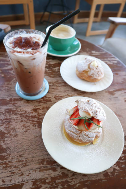 istock choux cream or cream puff, eclair or strawberry choux cream  , iced cocoa and coffee 2185179499