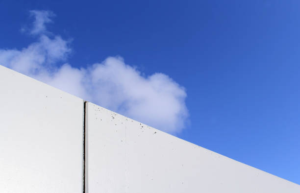 istock White concrete building wall against a blue sky with a cloud abstract textured background 2185179613