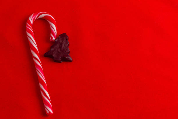 Christmas card concept, lollipop and chocolate tree on red background High quality photo.