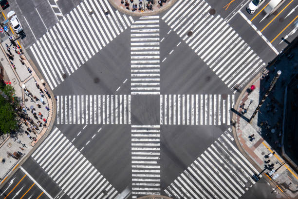 Ginza crosswalk in Tokyo from a top view, featuring crowds of pedestrians and car traffic. Experience the vibrant activity and urban energy of this iconic district.