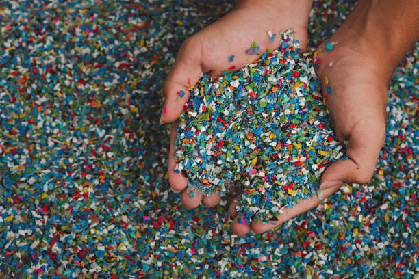 istock Hands hold clear white plastic pellets, raw materials for various manufacturing processes. These pellets are widely used in industries to produce products like packaging, bottles, and equipment parts. The white background highlights the pellets, making th 2185182481
