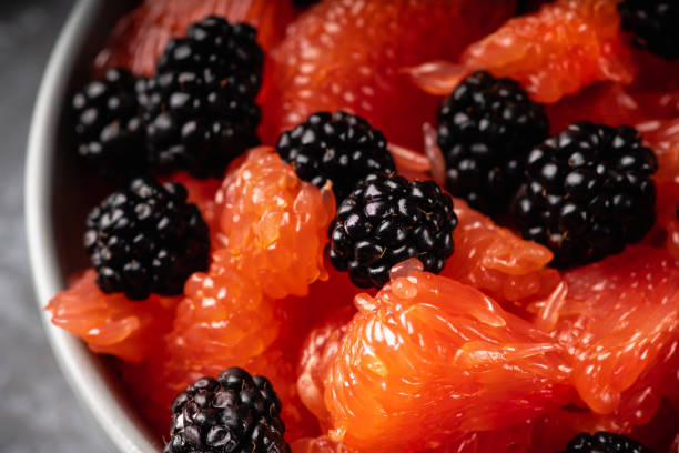 Fruit salad with grapefruit and blackberries in gray ceramic bowl