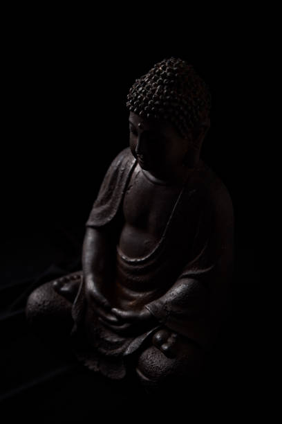 istock Meditating Buddha Statue on dark background. Close up. Copy space. 2185186395