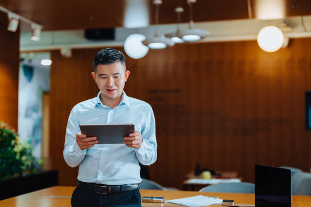 istock Asian young businessman using digital tablet and standing in meeting room. 2185186677