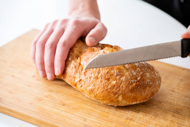 istock hands cut homemade rye bread on a wooden table 2185189621