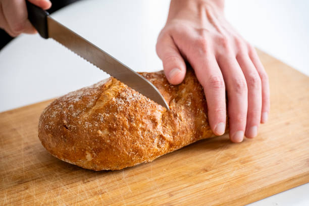 istock hands cut homemade rye bread on a wooden table 2185189622