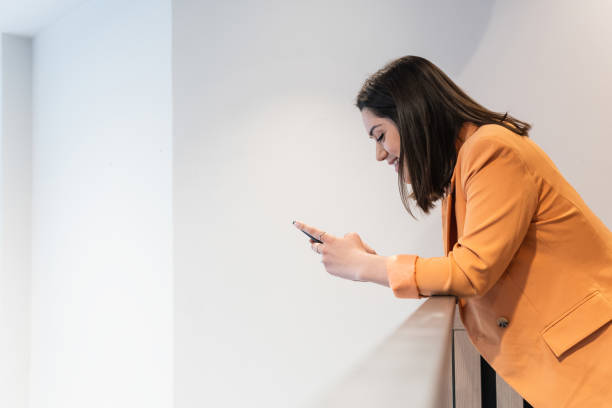 istock Delighted woman browsing smartphone in office 2185197037