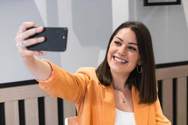istock Cheerful woman taking selfie on smartphone in cafe 2185197547