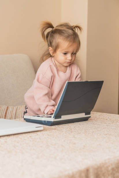 istock Modern Childhood Concept: Toddler Using Laptop In Comfortable Home Setting. Fun Technology Moment For Toddler Using Laptop. 2185199705