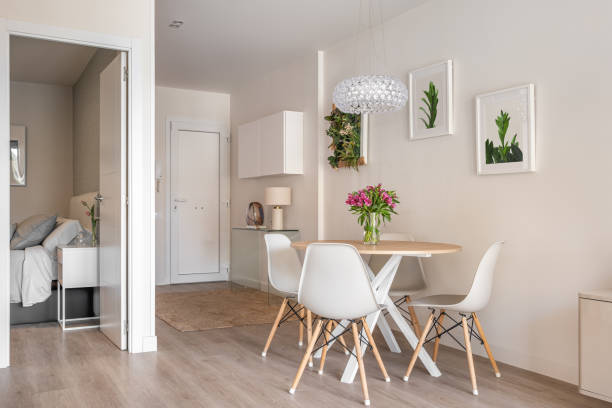 istock Stylish interior in a compact apartment with a spacious combined living room with table, chairs and decorative accessories overlooking the open bedroom. Cozy city apartment 2185200338