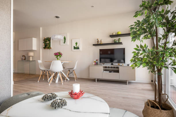 Modern interior in a compact apartment with a spacious combined living room with table, chairs and decorative accessories overlooking the TV and coffee table. Cozy city apartment