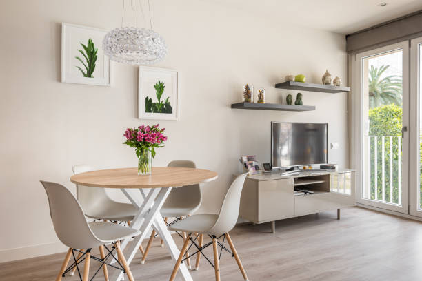 istock Cozy stylish living room with a round dining table, TV and panoramic windows and decorative accessories. The concept of a modern urban apartment for newlyweds 2185200411